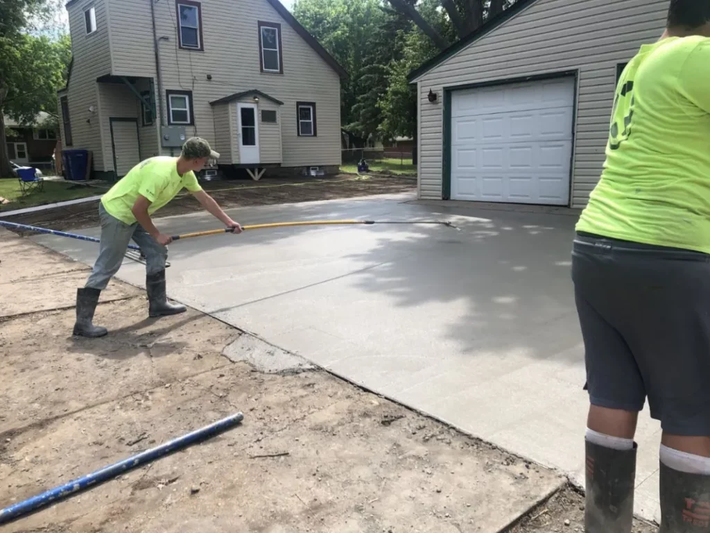 Crew finishing a concrete driveway slab in st paul minnesota